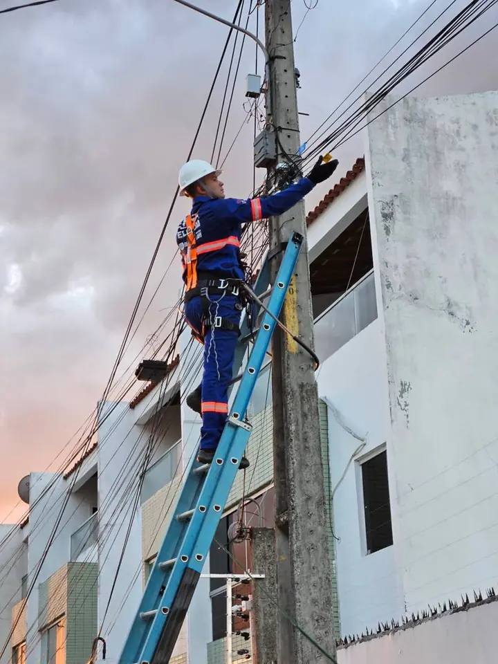Técnico da Atel instalando fibra ao entardecer