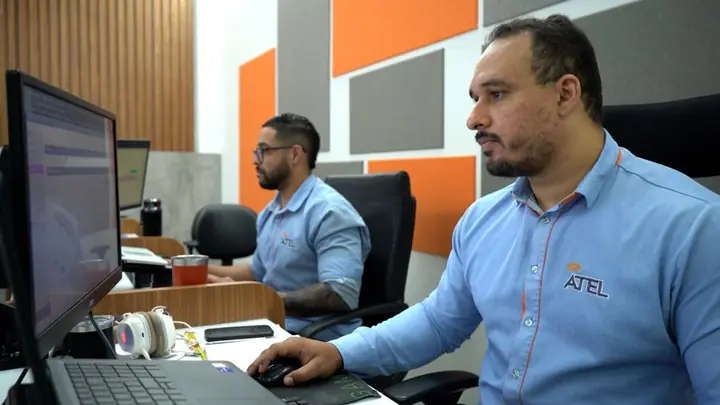 Dois colaboradores da Atel de uniforme trabalhando na central