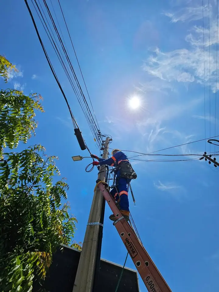 Técnico da Atel trabalhando em poste com escada