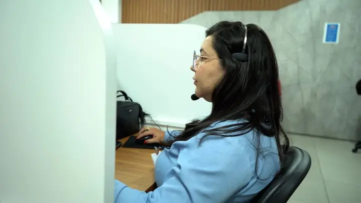 Atendente da Atel com headset no atendimento ao cliente