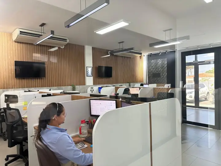 Interior da loja Atel com atendente em baia e ambiente com painéis de madeira